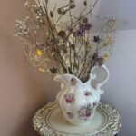 Veľkonočné dekorácie vo váze s jarnými vetvičkami, sušenými kvetmi a drobnými ozdobami