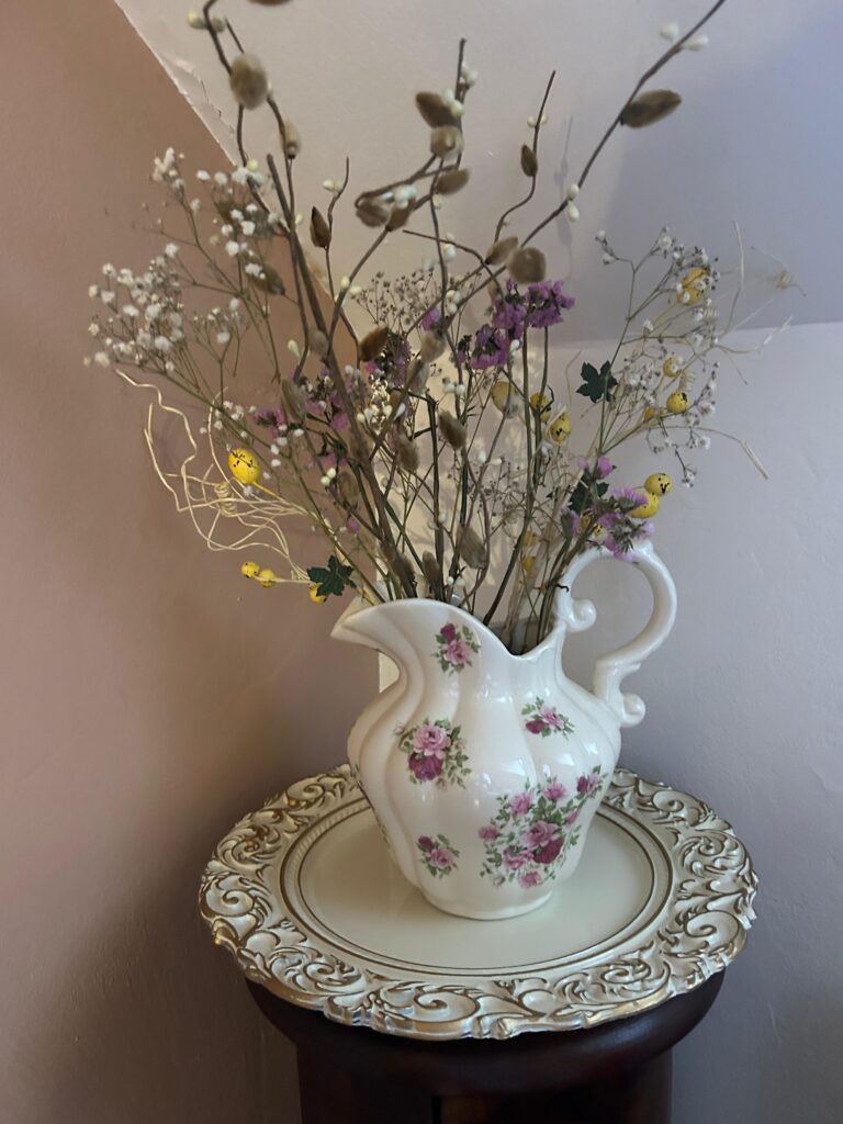 Veľkonočné dekorácie vo váze s jarnými vetvičkami, sušenými kvetmi a drobnými ozdobami