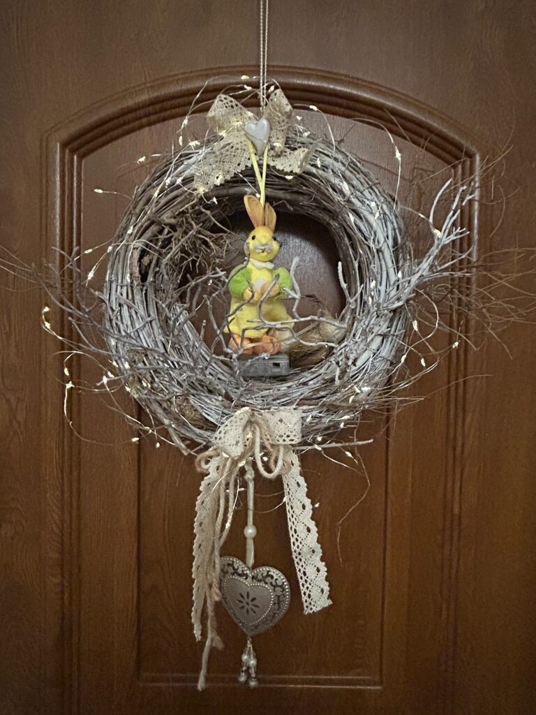 Veľkonočný veniec na dverách s prúteným základom, zajačikom a jemnými ozdobami